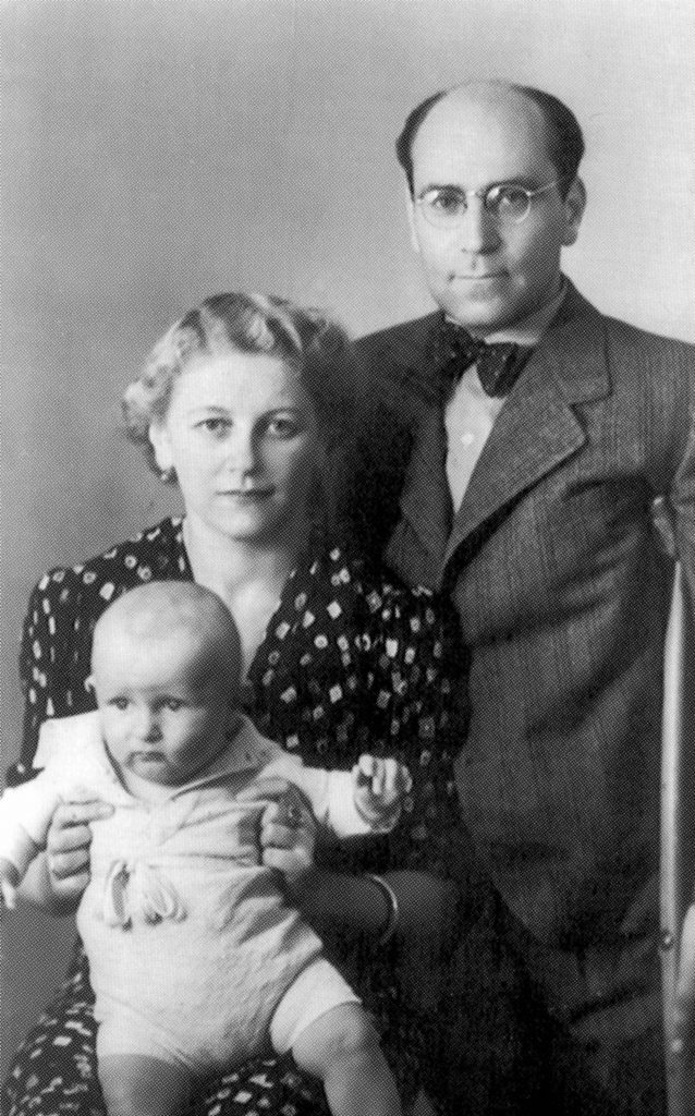 Grau eingefärbtes Familienporträt: Vorne Baby Hans auf dem Schoß seiner Mutter Stella Morgenstern. Dahinter steht Egon Morgenstern mit einer Krücke unter seiner linken Schulter.